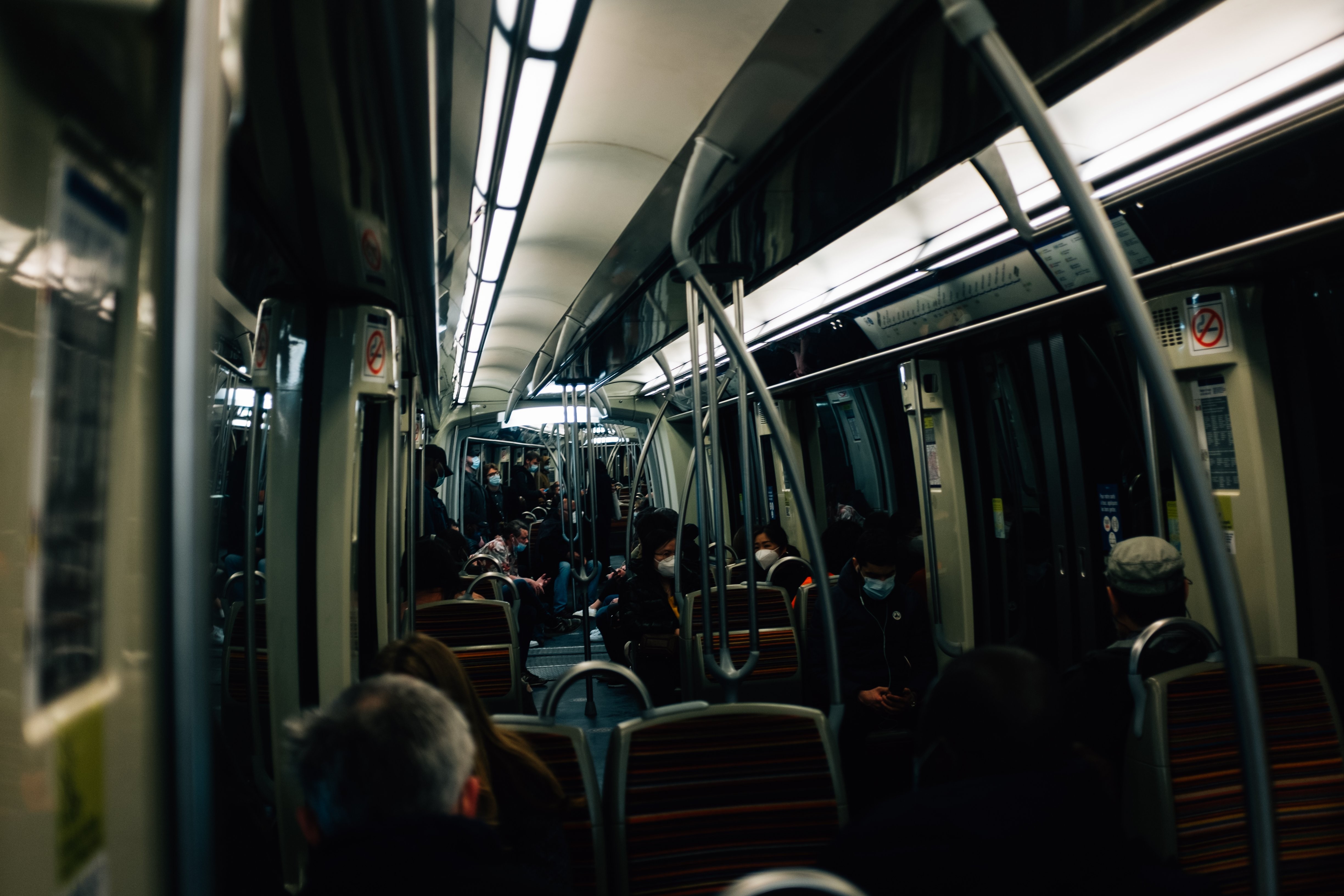 Dimly Lit Transit Vehicle Interior: Passengers Near Doors — Photo