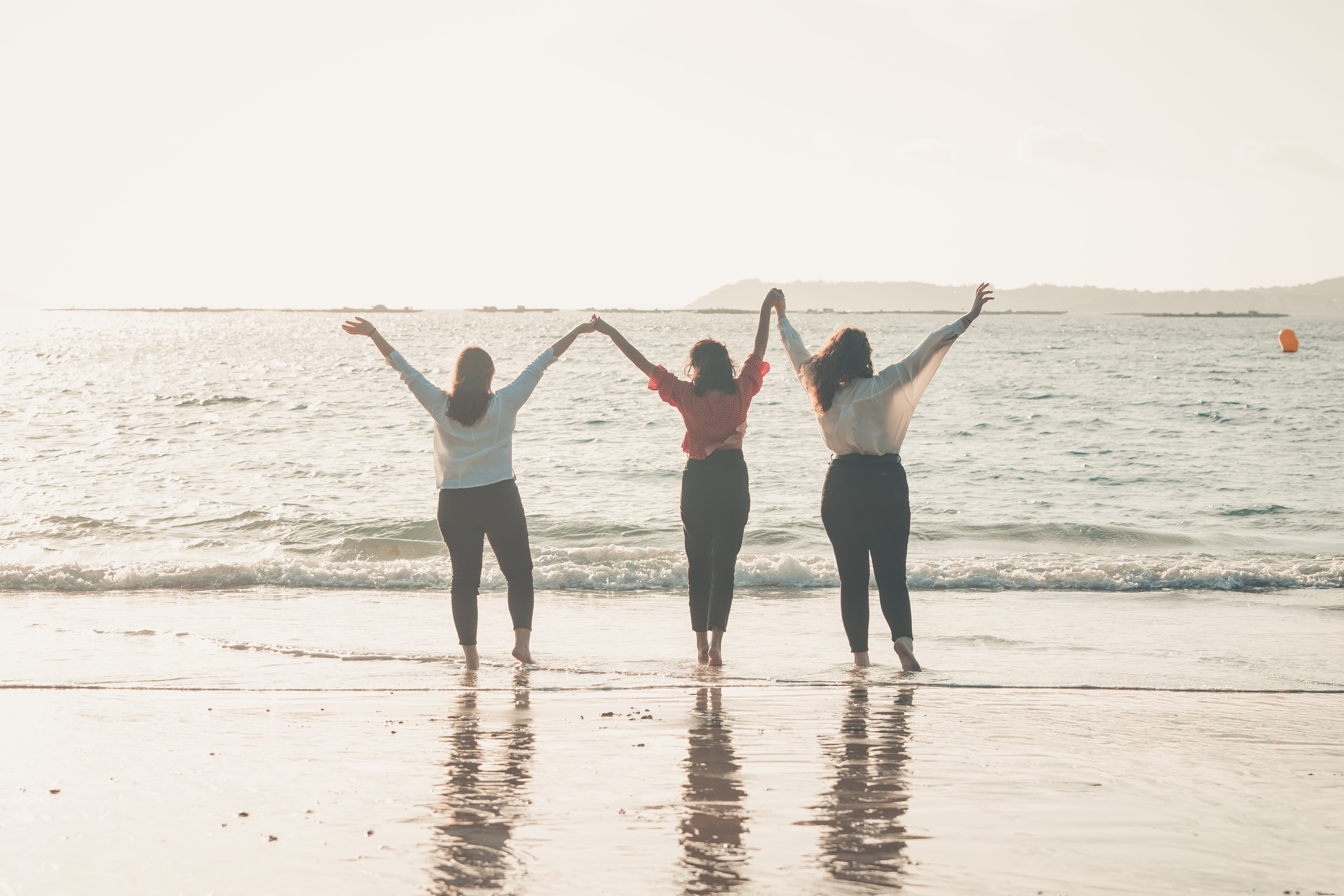 Three People Holding Hands with Arms Raised to the Sky – A Powerful Moment of Unity