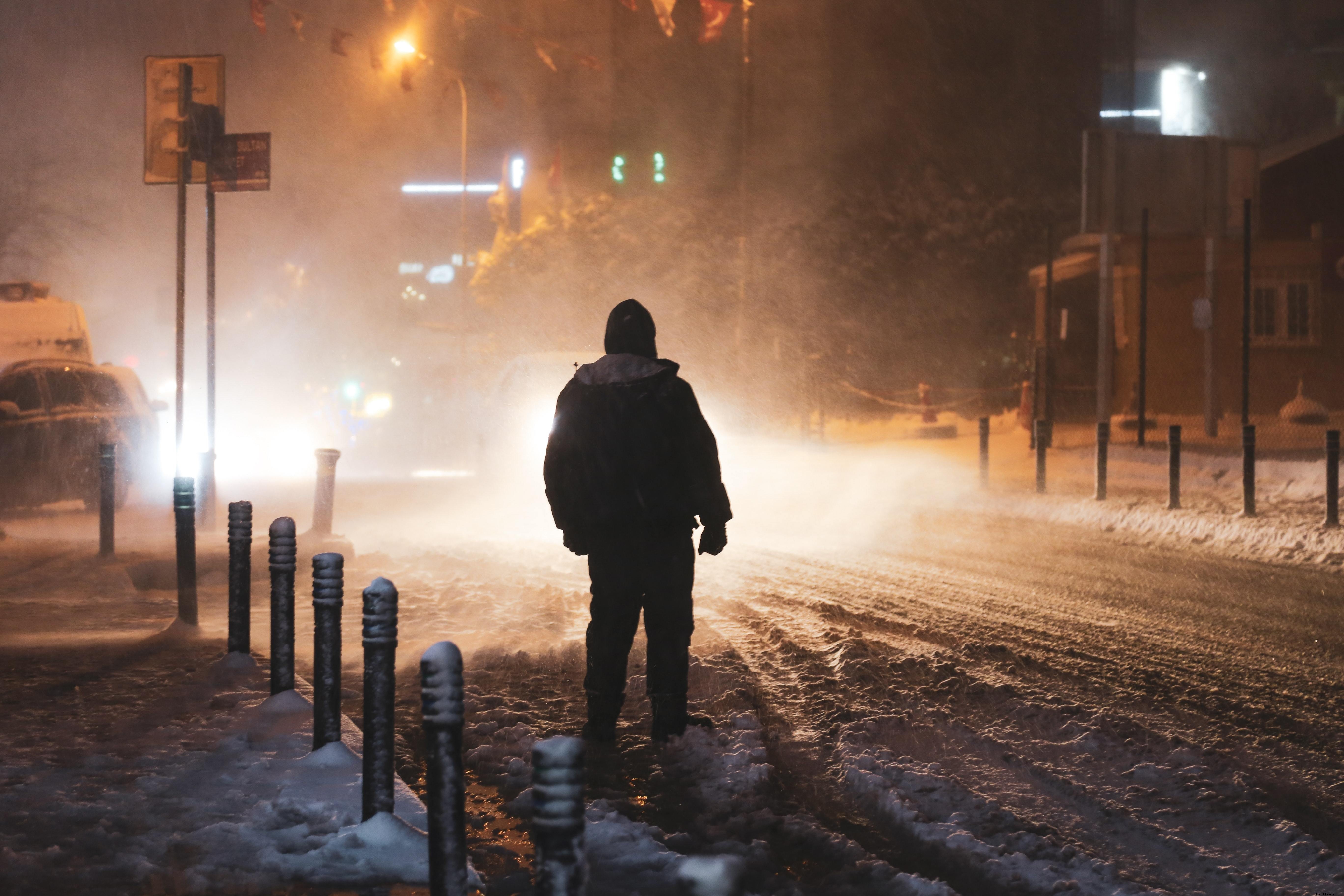 Person Illuminated by Street Lights Amid a Snow Storm – High‑Resolution Photo