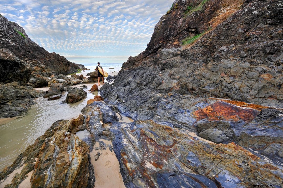 Stunning Photo of Rocky Shoreline with Surfer Holding Board