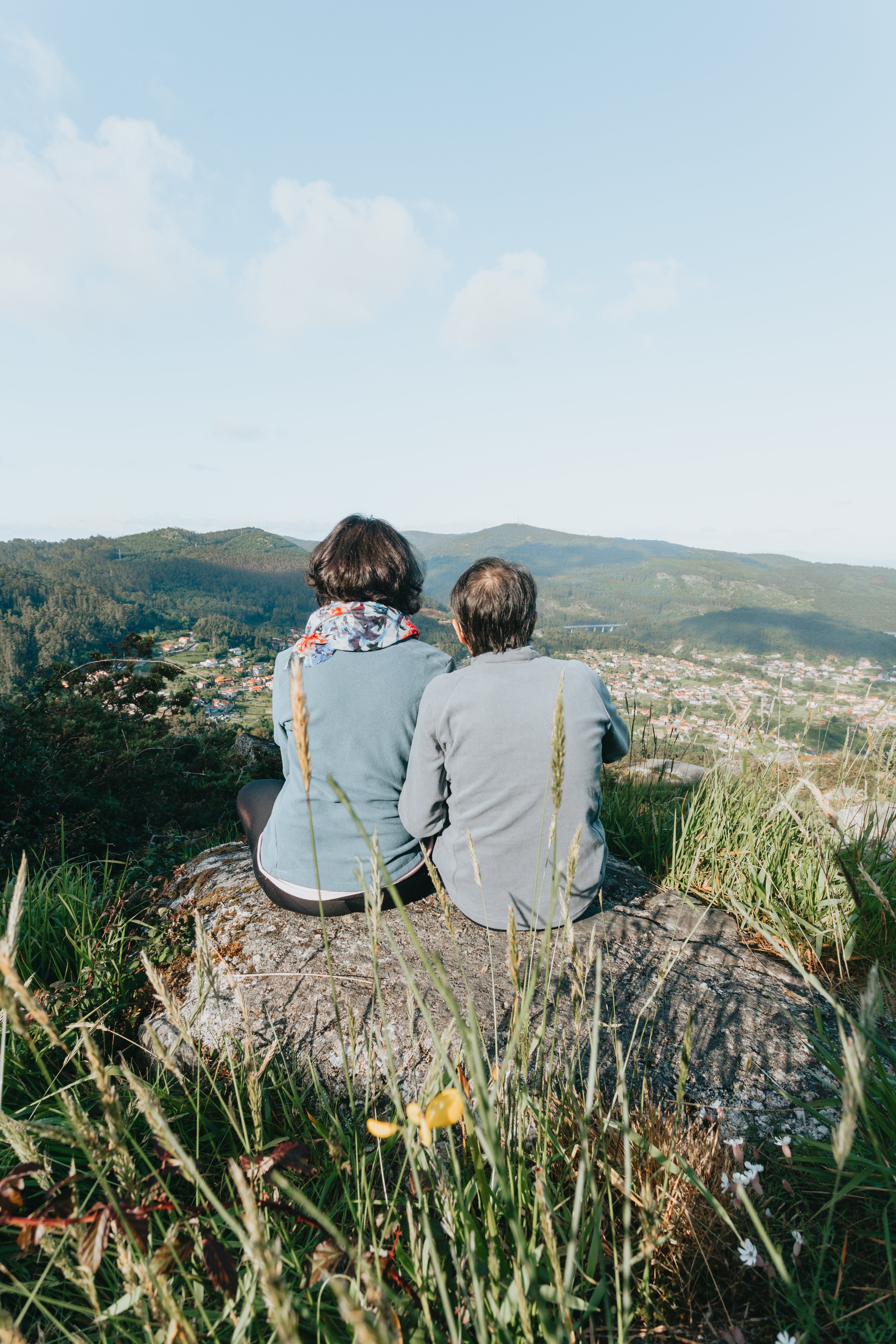 Two People Resting on a Rock, Facing Away from the Camera – Scenic Photo