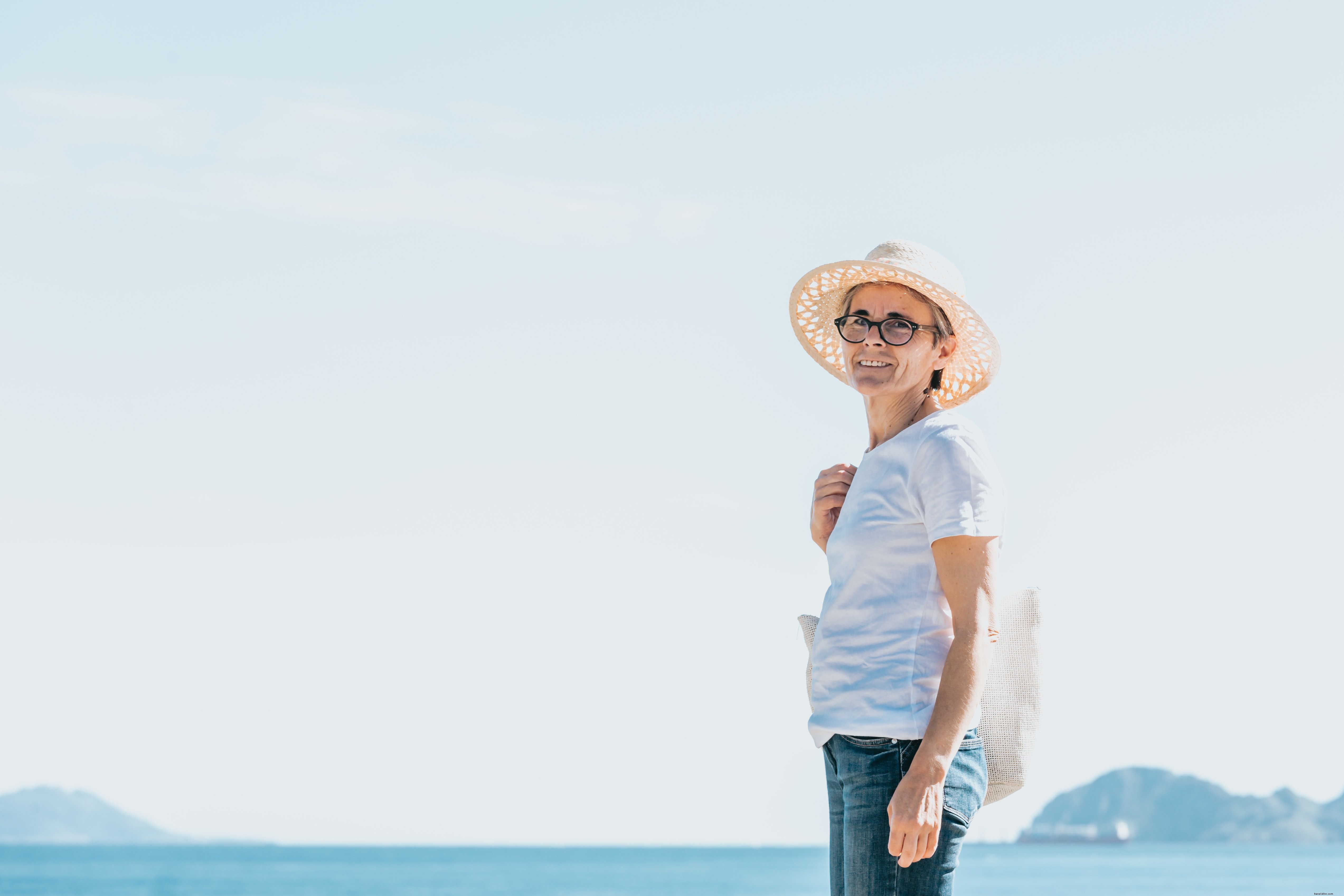Woman Stands by Open Water Wearing a Straw Hat – Captured Moment