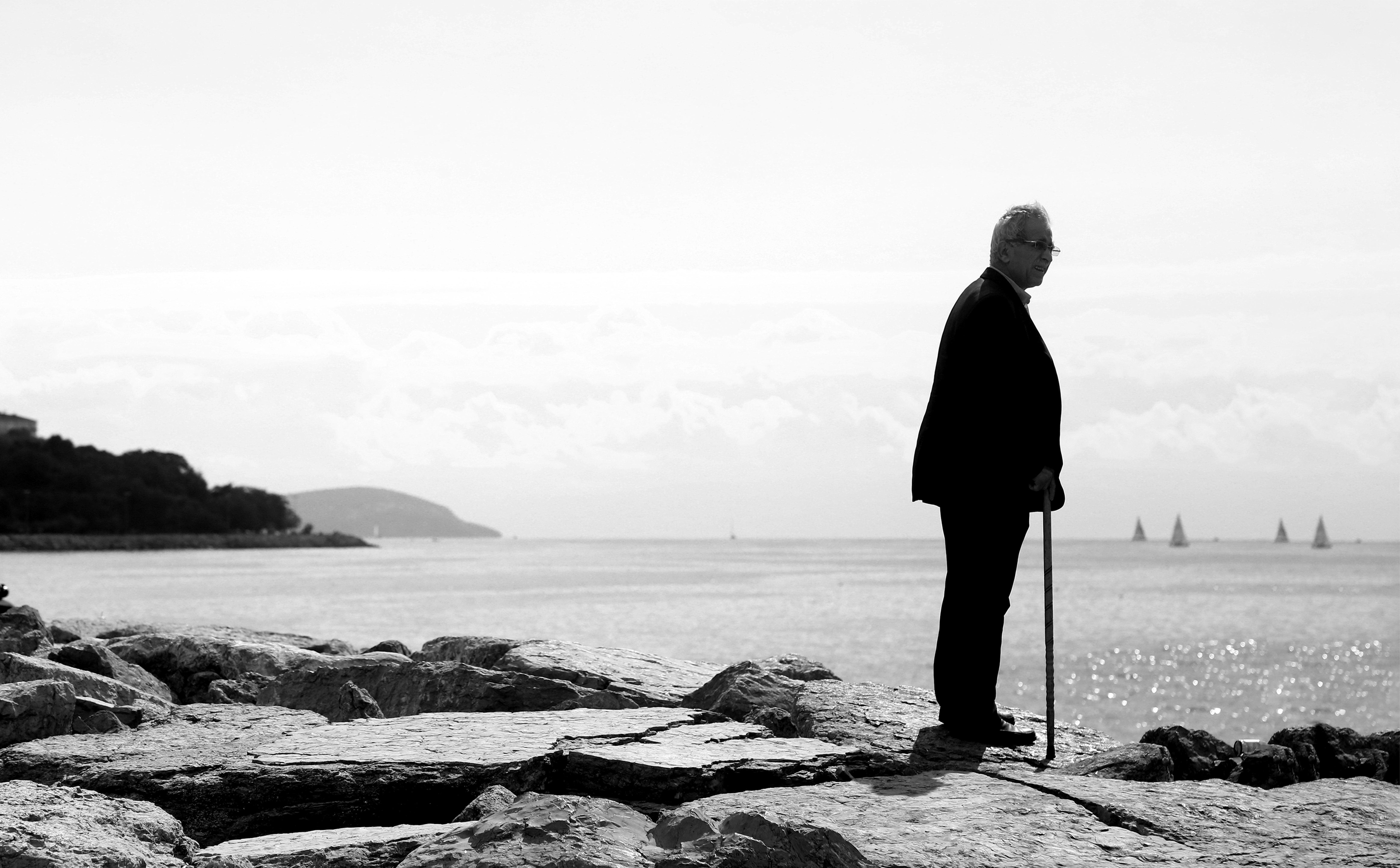 Monochrome Portrait: Man Standing Alone, Gazing Beyond the Shore