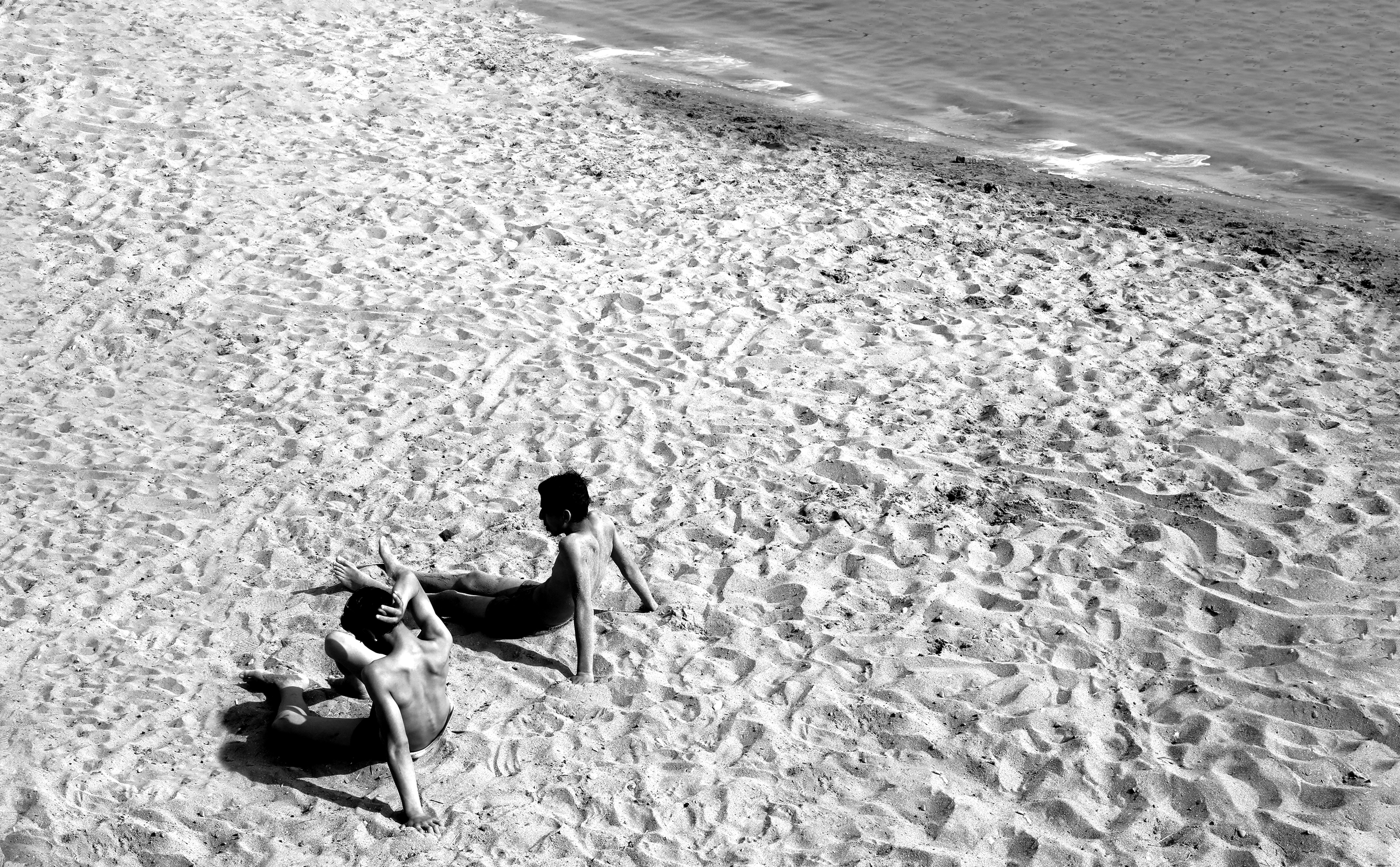 Black‑and‑White Beach Portrait: Two People Relaxing on a Sandy Shore