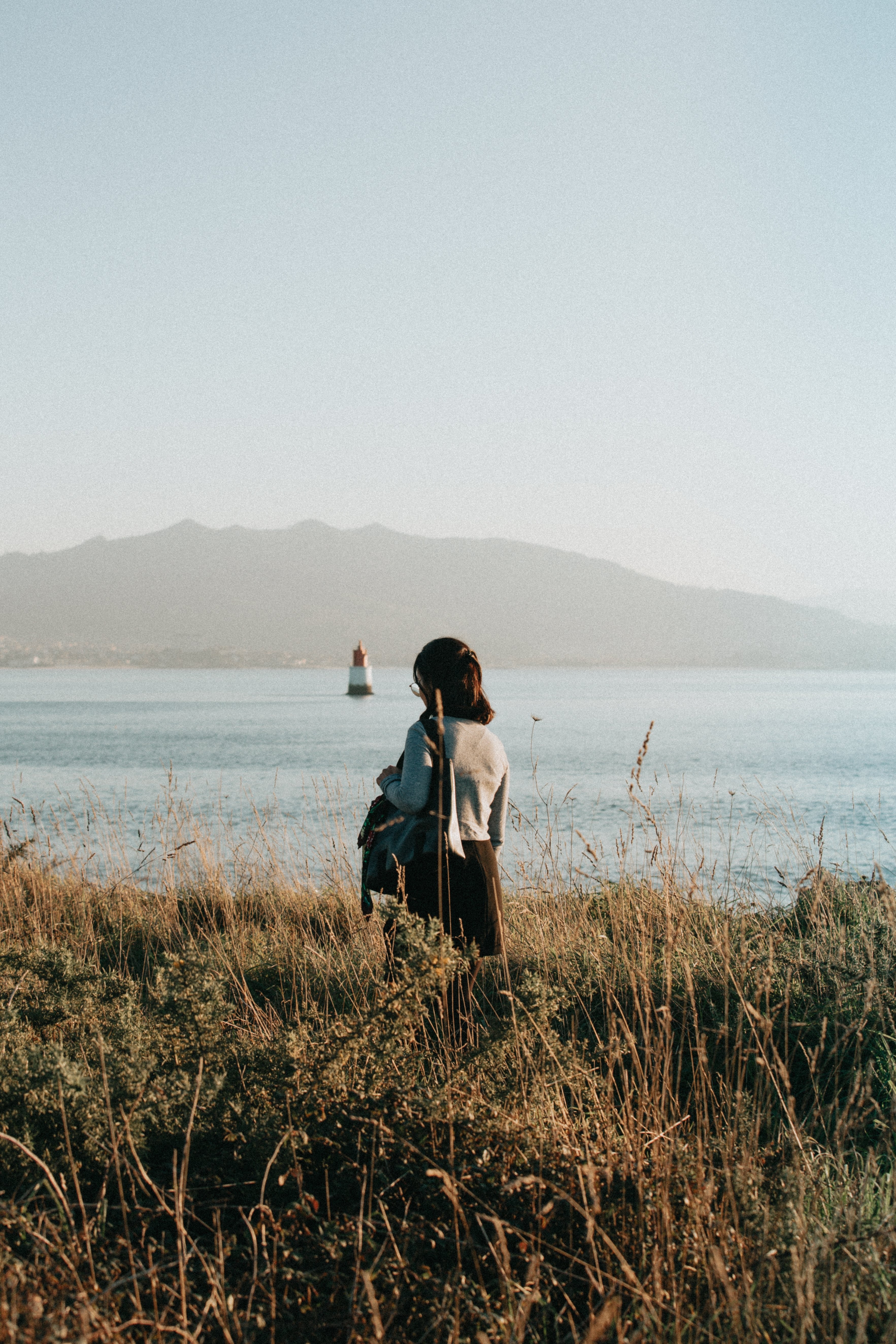 Intimate Portrait in Tall Grass: Person with Head Down