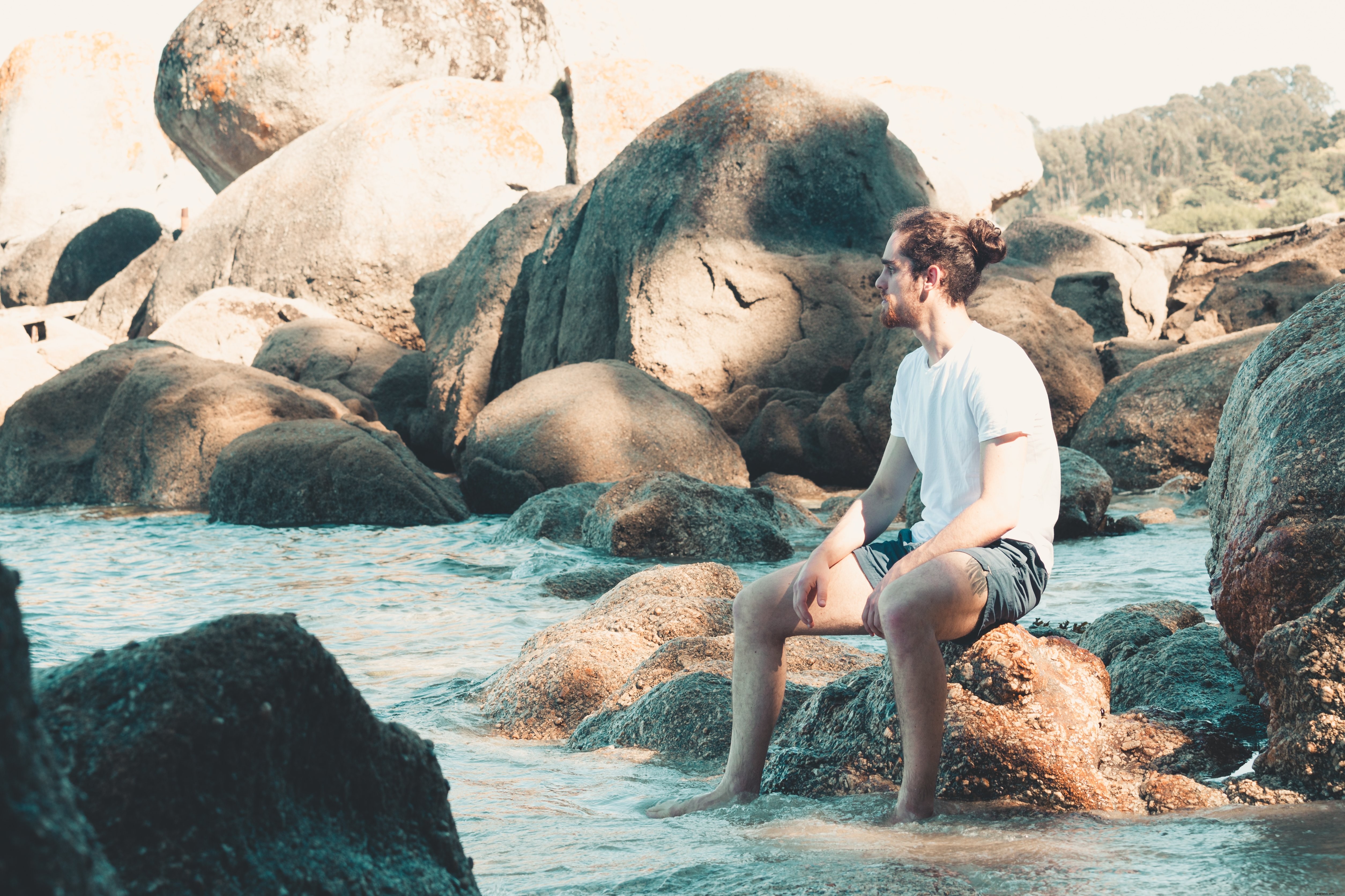 Contemplative Pause: A Man on a Rock with Feet in Water