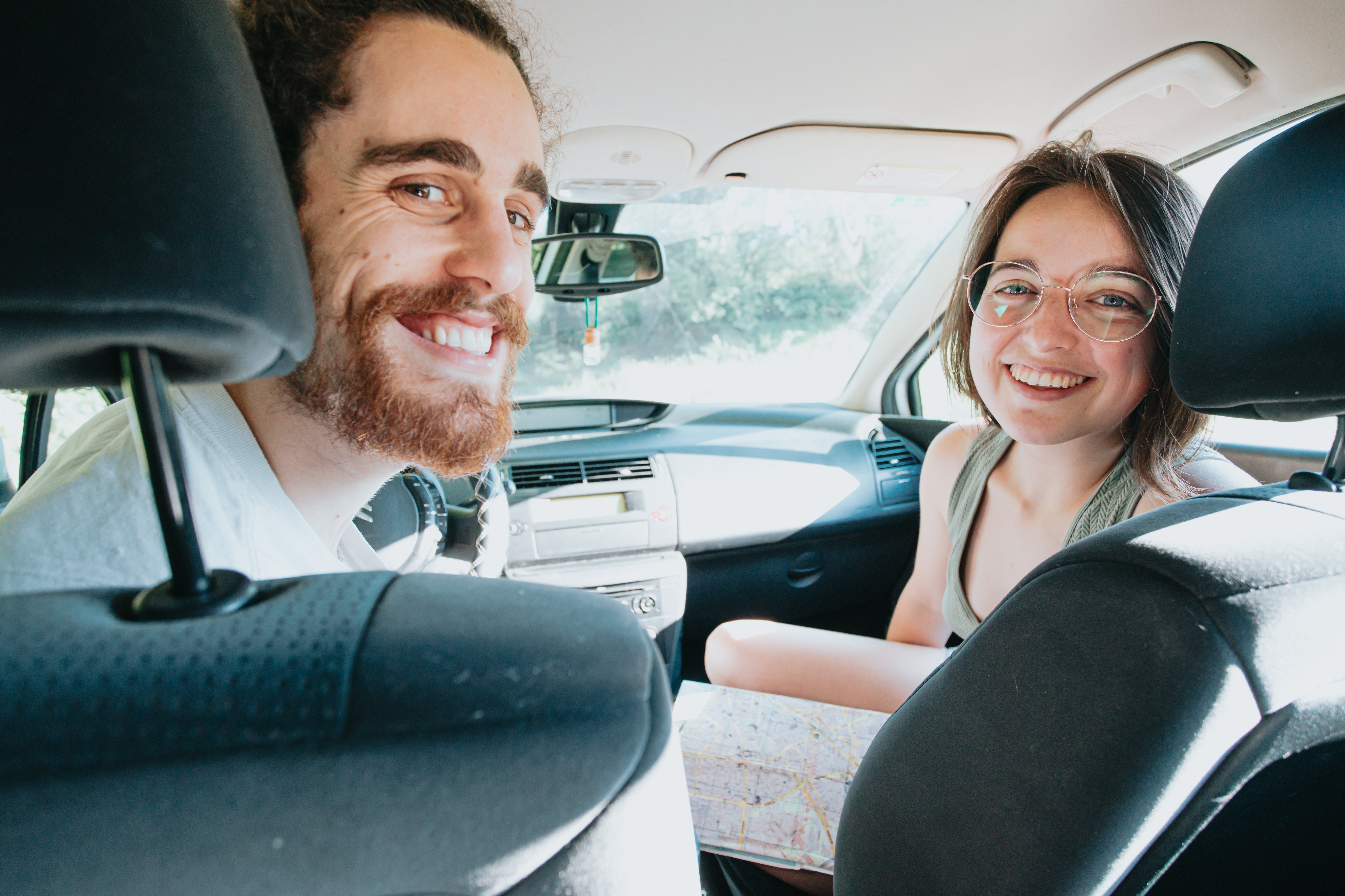 Smiling Duo Inside a Car: A Heartwarming Travel Snapshot