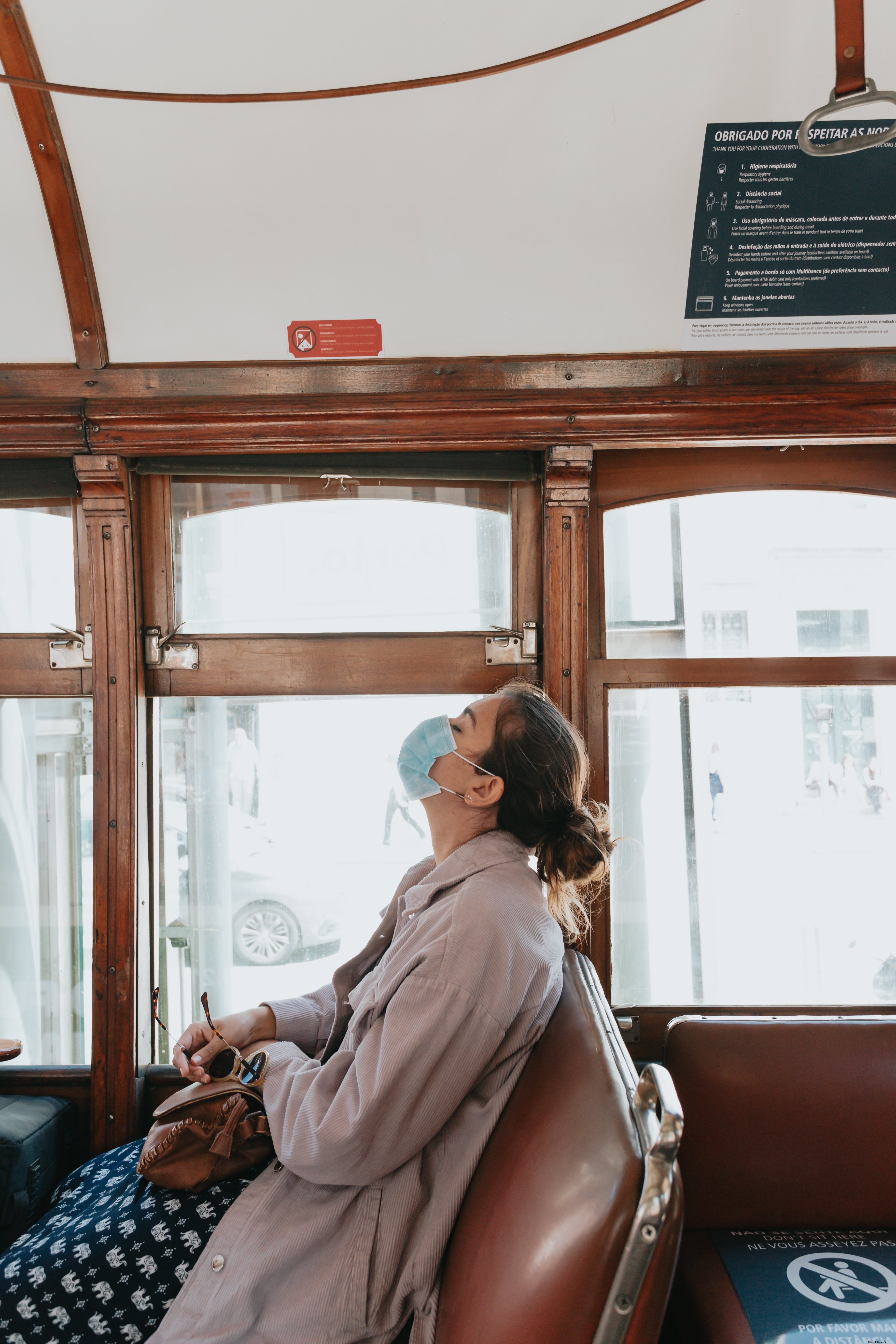 Woman in Blue Face Mask Seated on Brown Bench – A Serene Moment