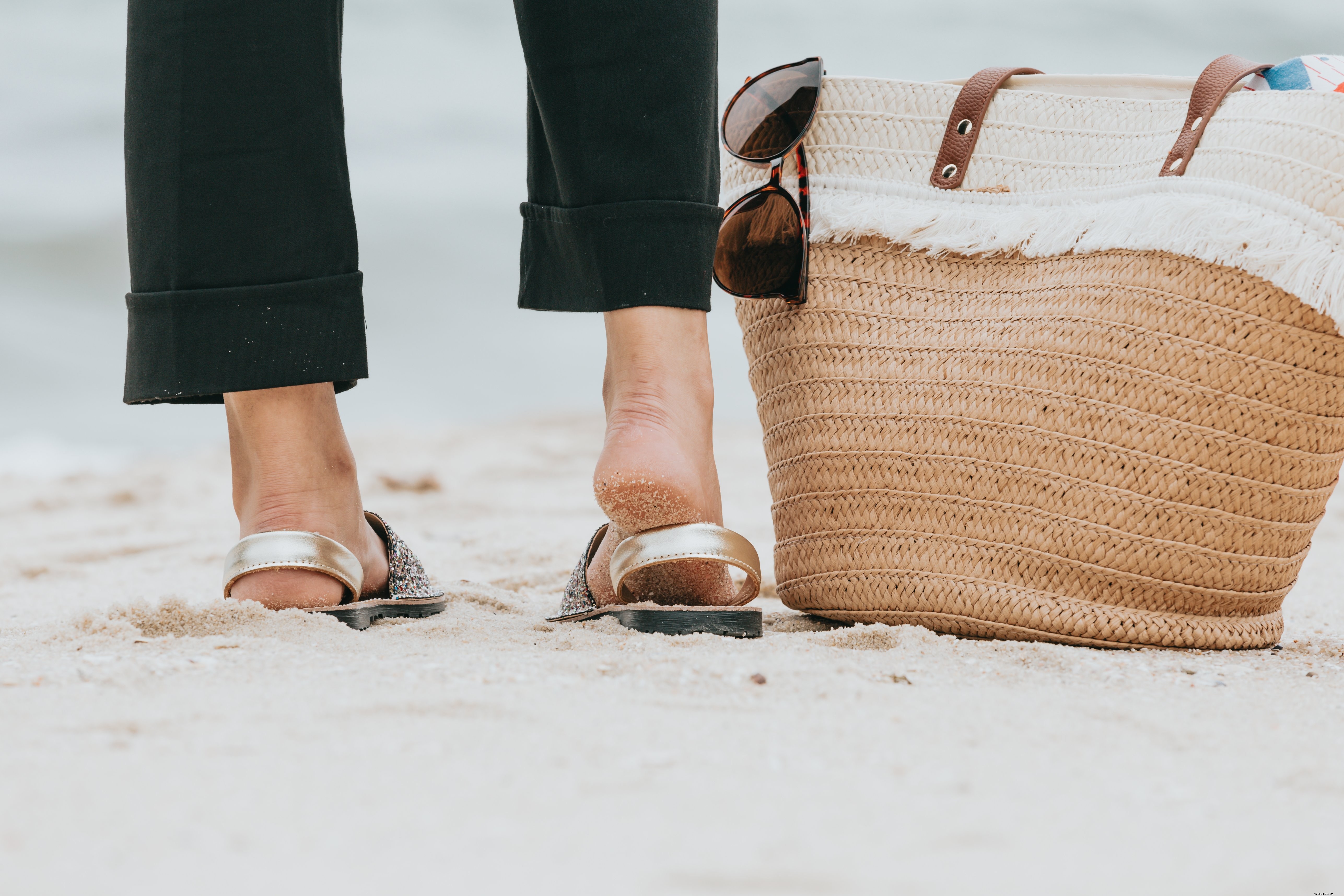 Beach Footwear Snapshot: Legs on Sandy Shore beside a Beach Bag