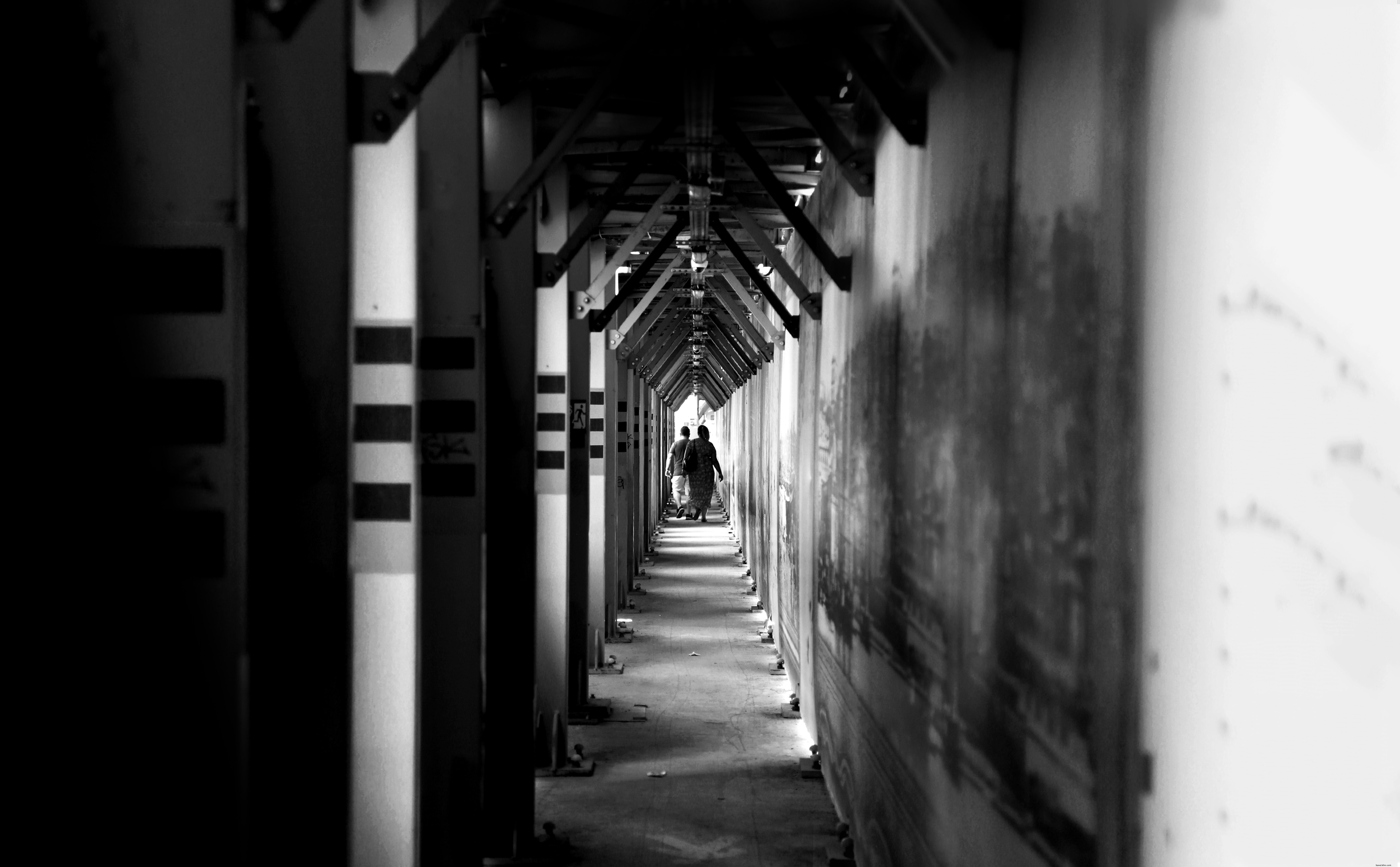 Exploring a Long Hallway: Two People Walking in a Photo