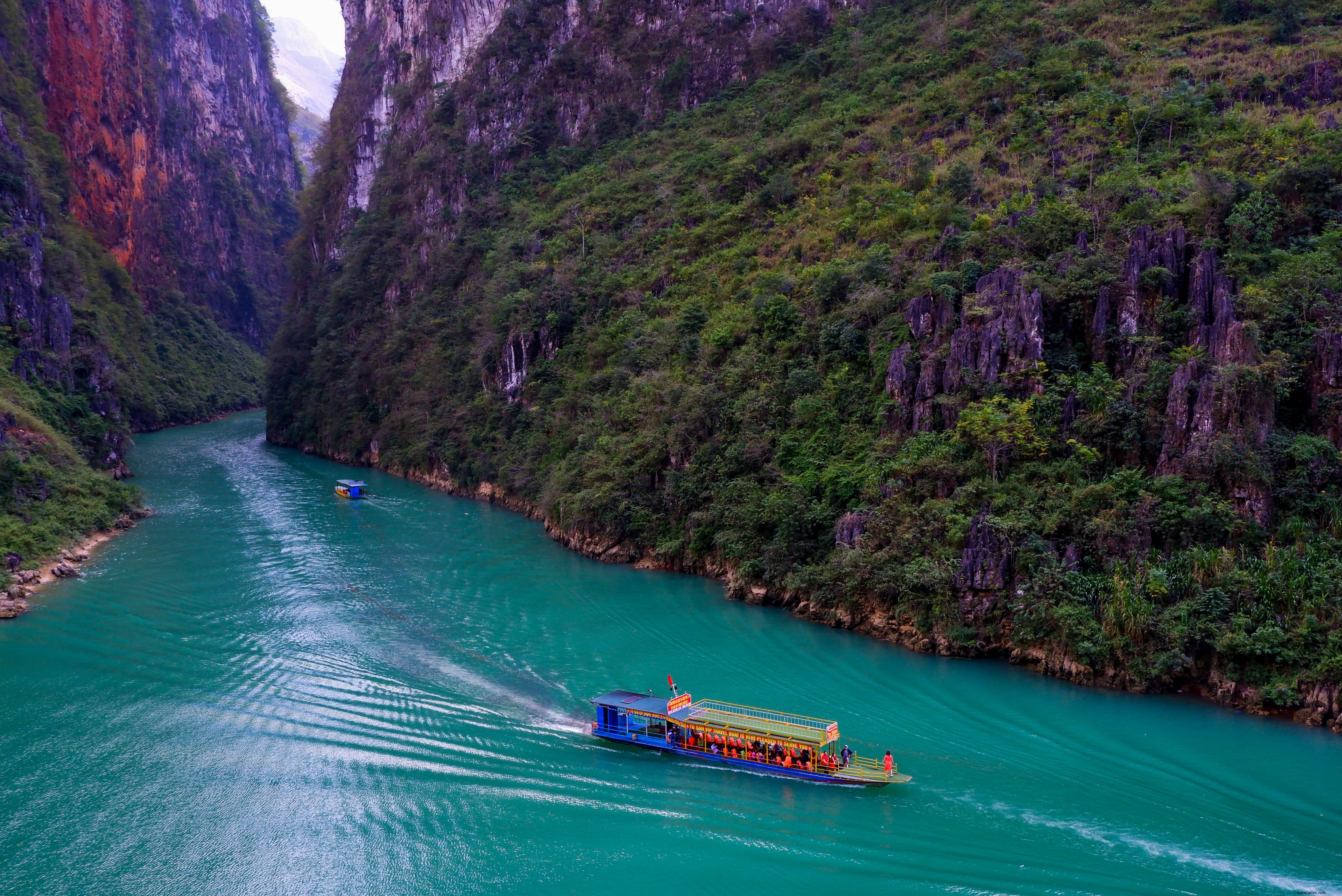 Boat Glides Along River Amid Lush Green Mountains – Stunning 2021 Photo