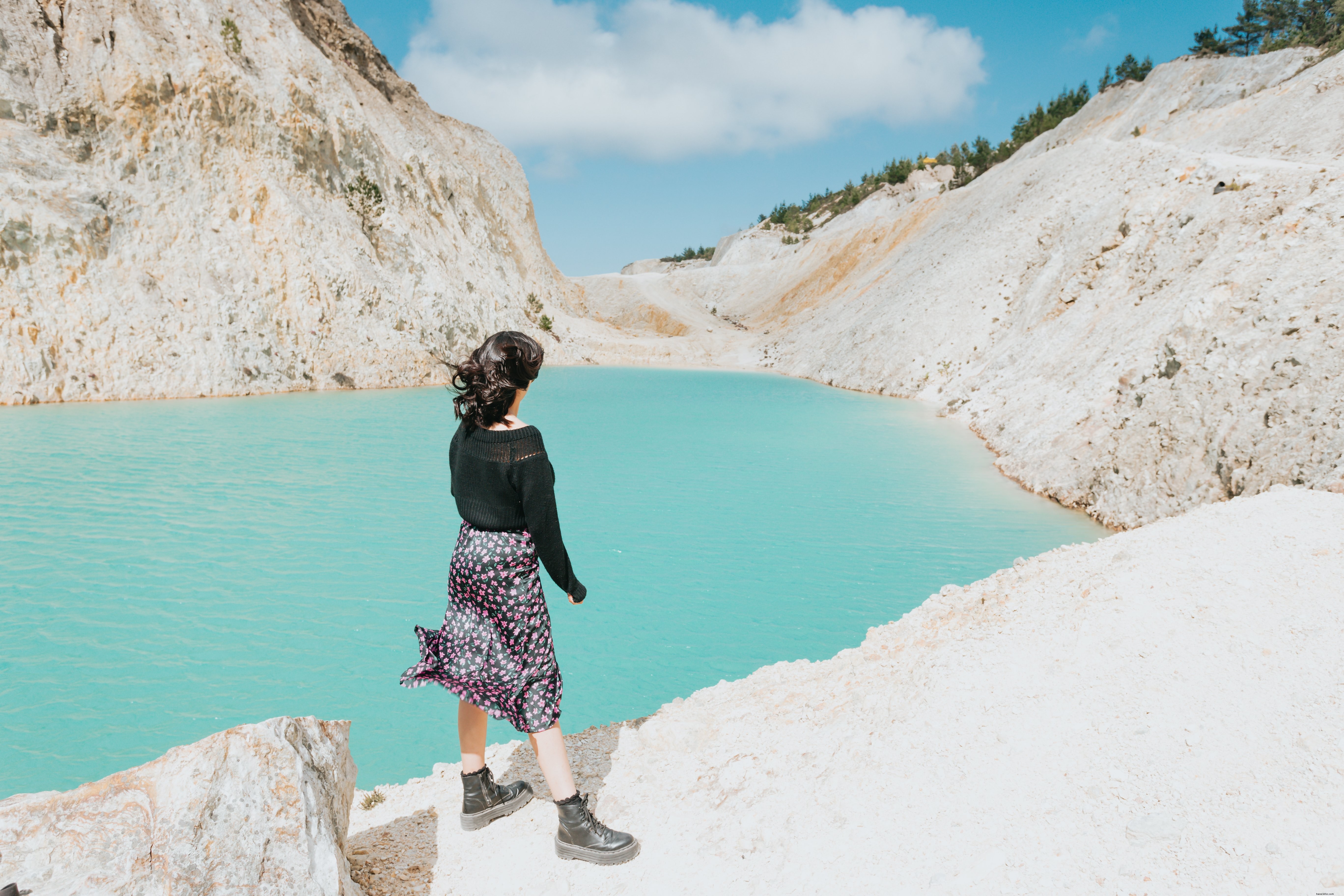 A Person Stands Beside a Serene Blue Lake