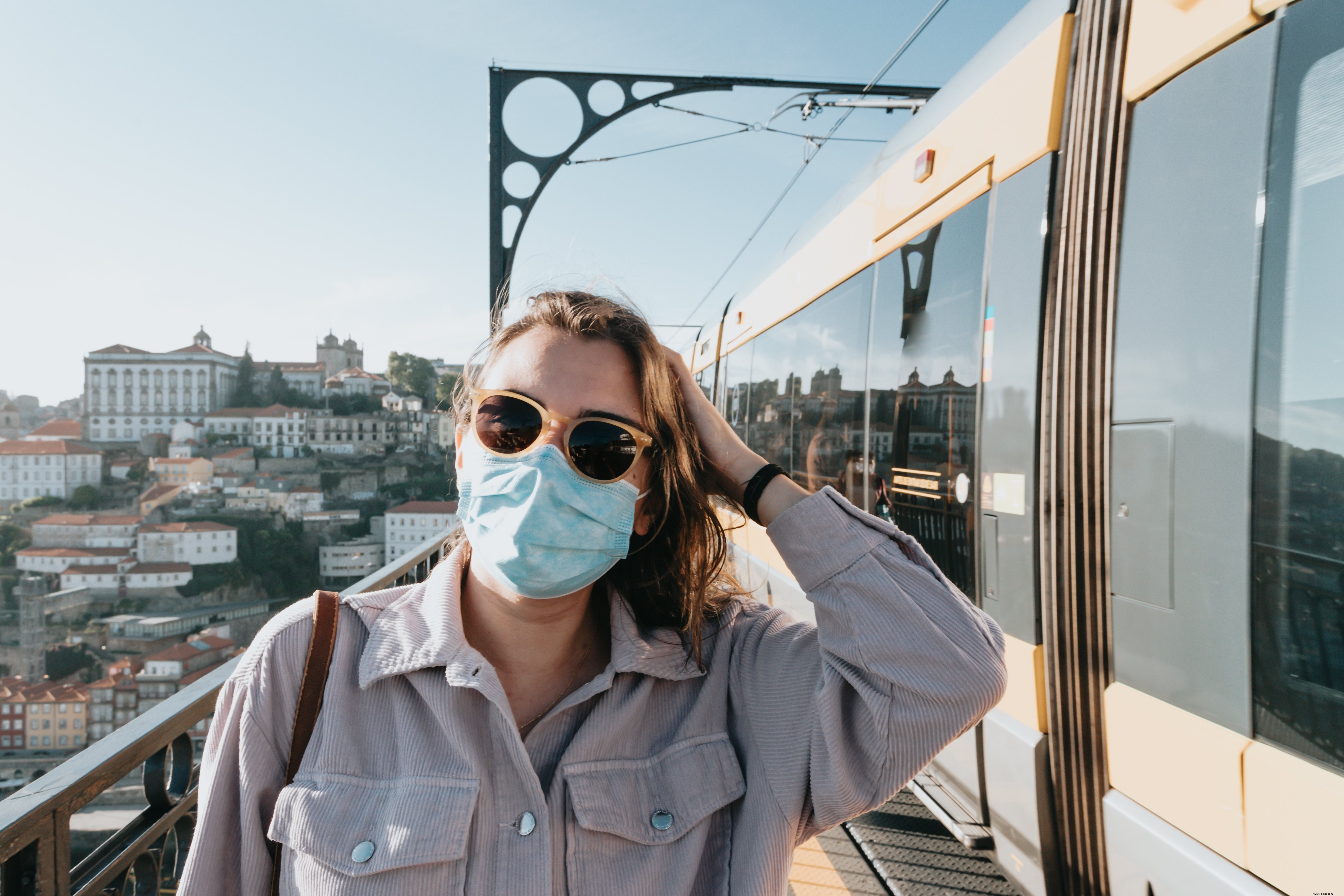 Commuter Stands by Train in Full PPE: Sunglasses & Mask Highlight Public Transit Safety