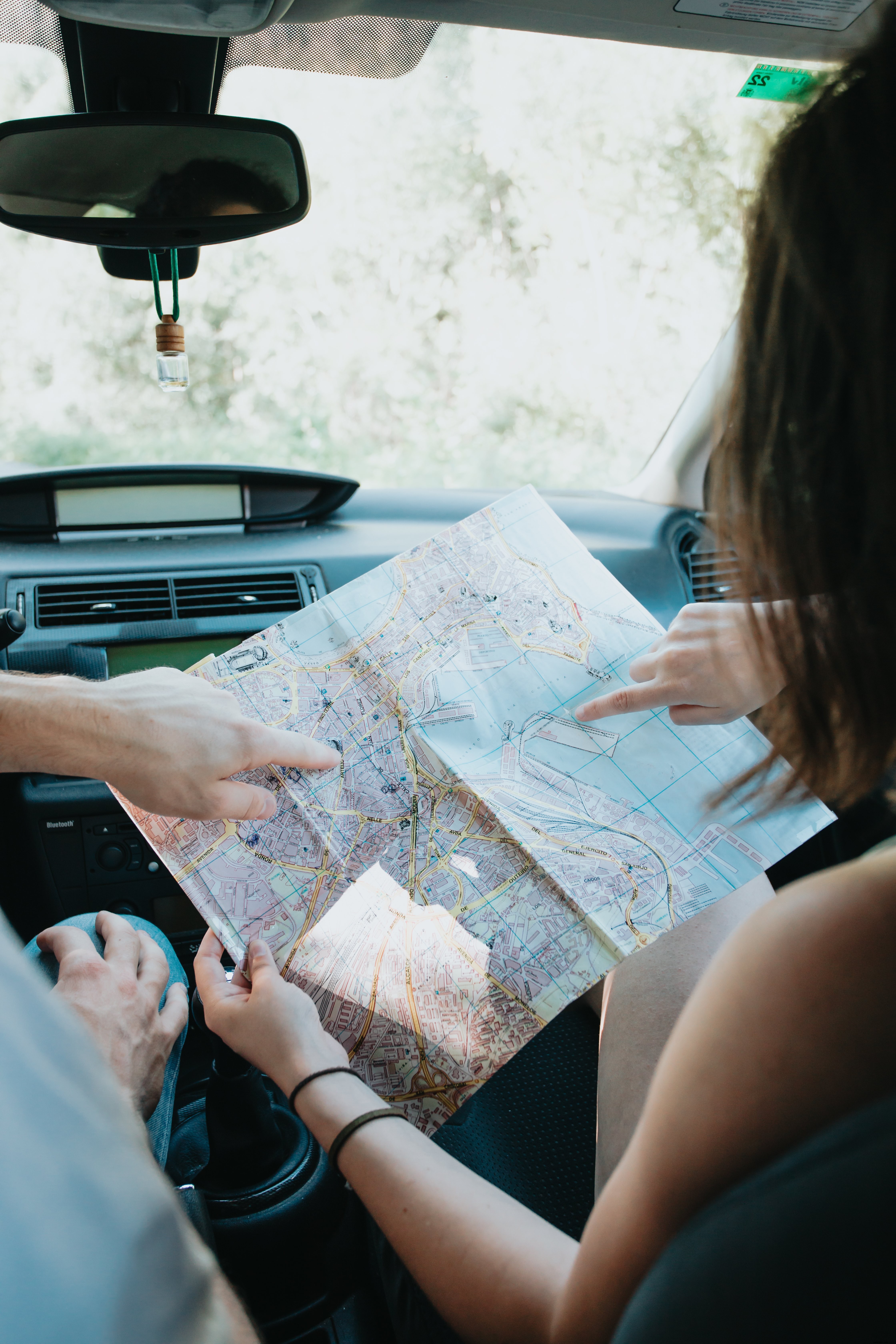 Two People Hold a Map Inside a Car – A Travel Snapshot